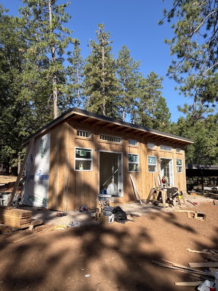 Shed-roof ADU under construction by K&K ProBuild on a pine-shaded Southern Oregon job site