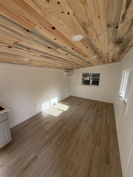 Bright finished ADU interior with luxury vinyl plank flooring and a natural wood ceiling