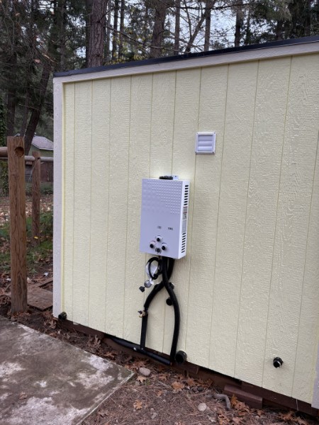 Exterior tankless water heater providing on-demand hot water for an ADU